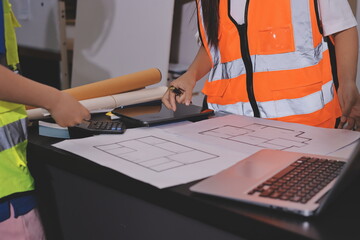 Closeup of team of industrial engineers meeting analyze machinery blueprints consult project on...