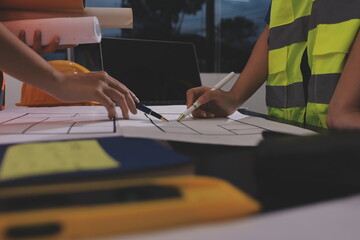 Closeup of team of industrial engineers meeting analyze machinery blueprints consult project on...