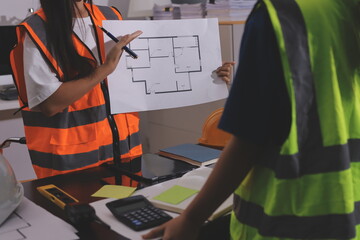 Closeup of team of industrial engineers meeting analyze machinery blueprints consult project on...