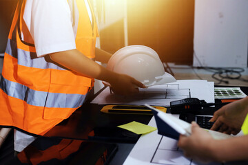 Closeup of team of industrial engineers meeting analyze machinery blueprints consult project on...