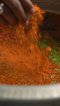Masala Powder getting Sprinkled into a Pot where Bisi Bele Bath is being Cooked, a traditional Karnataka Rice Dish
