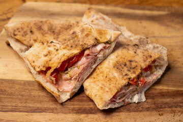 hot italian ham sandwich on wooden plate
