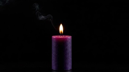 Purple candle burning on dark background with copy space