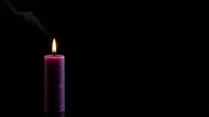 Purple candle burning on dark background with copy space