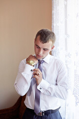 A man is getting ready for a formal event, putting on a tie