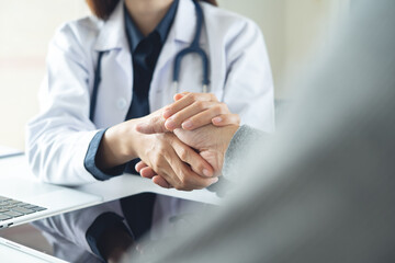 Close up, female doctor holding her senior male patient's hands. Giving mental Support. Doctor...