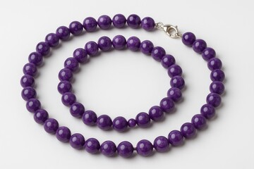 Obraz premium Purple bead necklace displayed on a plain white surface