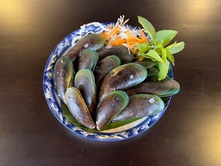 Steamed mussels with basil leaves, selective focus