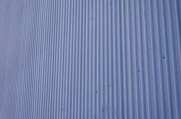 Obraz premium Muted Blue Corrugated Metal Sheet Featuring Vertical Ridges and a Distinct Pattern for Architectural or Abstract Backgrounds