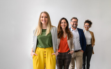 Portrait of confident business entrepreneurs standing in a row and smiling at camera against white...