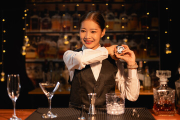 Professional female bartender preparing alcoholic drinks in a bar