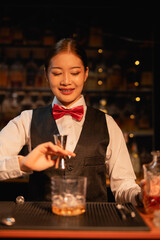 Professional female bartender preparing alcoholic drinks in a bar