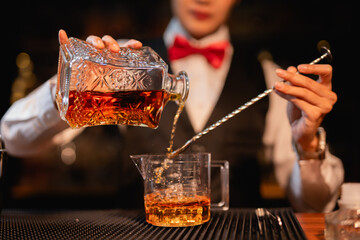 Professional female bartender preparing alcoholic drinks in a bar