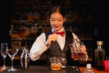 Professional female bartender preparing alcoholic drinks in a bar