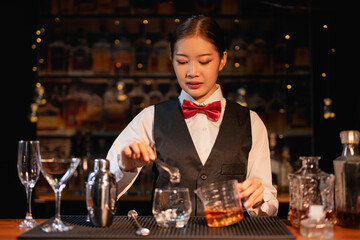  Professional female bartender preparing alcoholic drinks in a bar