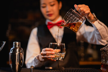  Professional female bartender preparing alcoholic drinks in a bar