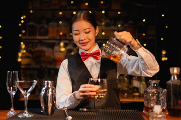  Professional female bartender preparing alcoholic drinks in a bar