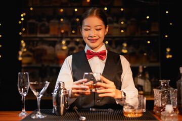 Professional female bartender preparing alcoholic drinks in a bar