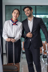 portrait pilot and attendant in uniform walking to work at airport terminal area,concept of air...