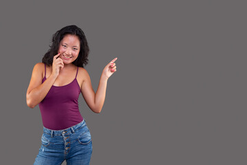 Smiling woman pointing sideways in casual outfit