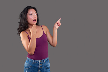 Surprised woman pointing to blank space
