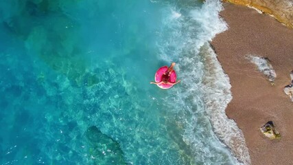 Aerial view of young woman swimming on inflatable donut in transparent turquoise sea. Holidays travel vacation in Thailand, Turkey - Powered by Adobe