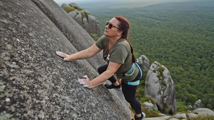 Confident Plus Size Woman Actively Engaged in Challenging Outdoor Rock Climbing Adventure