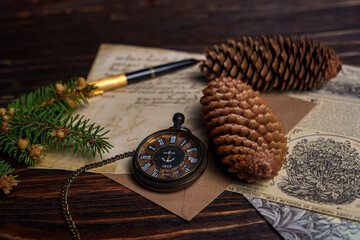 Vintage still life with pocket watch, pine cones, handwritten letter, and newspaper