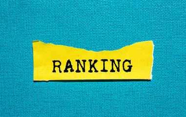 Ranking message written on ripped torn yellow paper piece on blue background. Conceptual ranking...