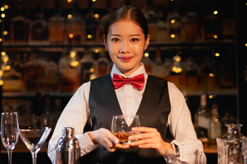 Professional female bartender preparing alcoholic drinks in a bar