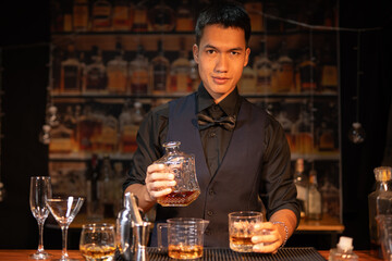 Professional male bartender preparing alcoholic drinks in a bar