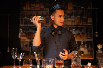 Professional male bartender preparing alcoholic drinks in a bar