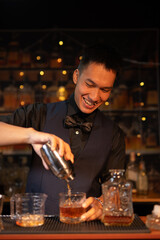 Professional male bartender preparing alcoholic drinks in a bar