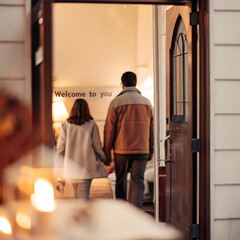 a couple walk into a house with a door that says q