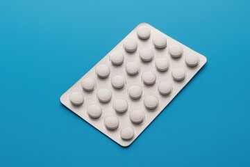 Pack of medication tablets on a vibrant blue backdrop