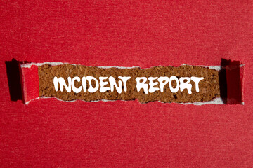 Incident report message written on ripped torn red paper on brown background. Conceptual incident report symbol. Copy space.