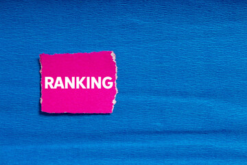 Ranking message written on ripped torn pink paper on blue background. Conceptual ranking symbol....