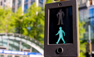 Green pedestrian light indicating safe crossing at Canary Wharf in London