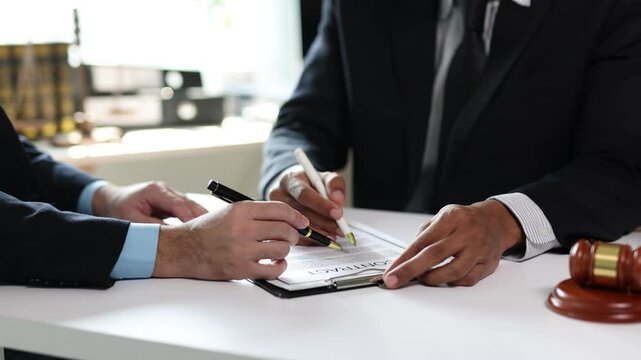 Lawyers signing contract in office meeting.