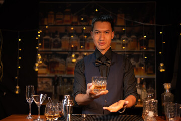 Professional male bartender preparing alcoholic drinks in a bar