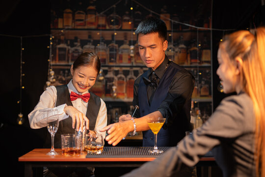  Professional female bartender preparing alcoholic drinks in a bar