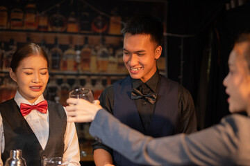 Professional female bartender preparing alcoholic drinks in a bar