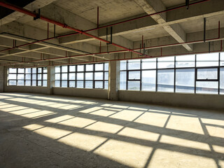 Expansive Industrial Interior with Natural Light and Dynamic Shadows