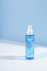 Hydrating facial mist bottle on calming blue background, capturing spa-like freshness. Ideal for self-care content and organic skincare marketing
