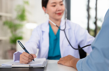 Asian doctor talk with patient about disease symptom, doctor use stethoscope listening lung of...