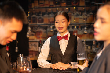 Professional female bartender preparing alcoholic drinks in a bar