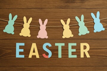 Easter-themed backdrop featuring paper bunny garlands and alphabet letters on a wooden surface
