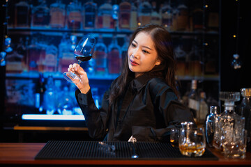 Beautiful young woman drinking alcohol at nightclub bar enjoying a pub party