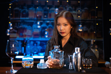 Beautiful young woman drinking alcohol at nightclub bar enjoying a pub party