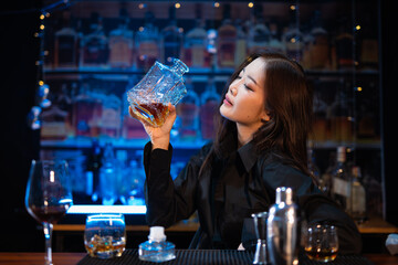 Beautiful young woman drinking alcohol at nightclub bar enjoying a pub party